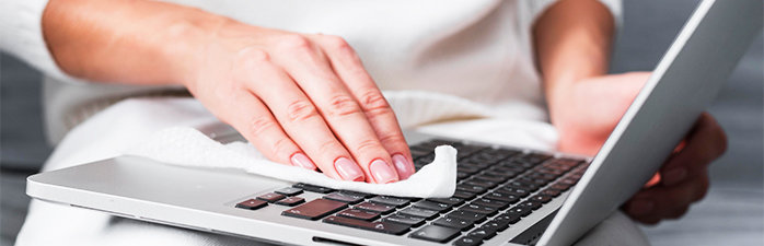 Person wiping computer keyboard